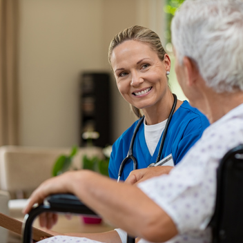 Care Home Nurse Chatting To Older Gent